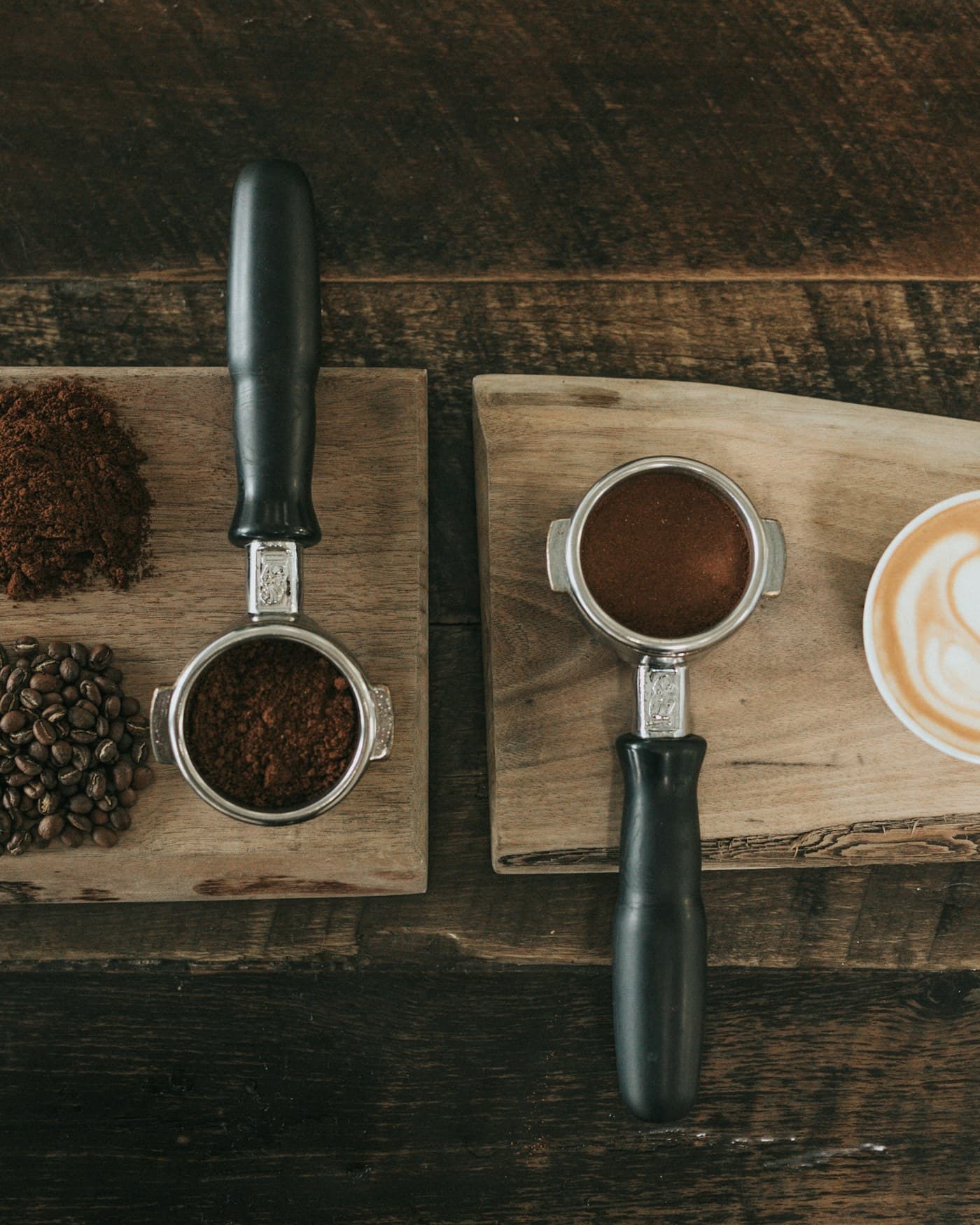 Freshly pulled espresso, ground coffee, and roasted beans on a wooden board